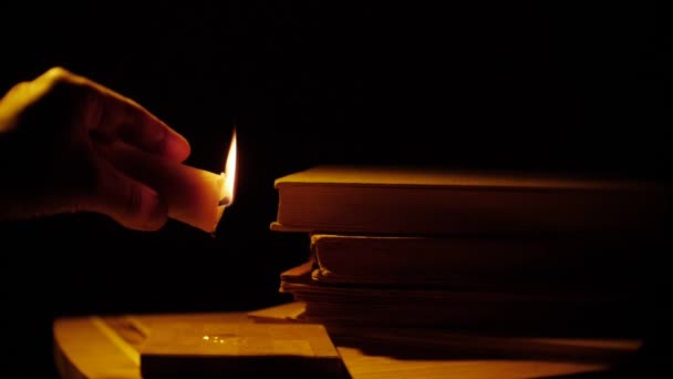 Books and candle. Fire and smoke. Leaking wax. — Stock Video