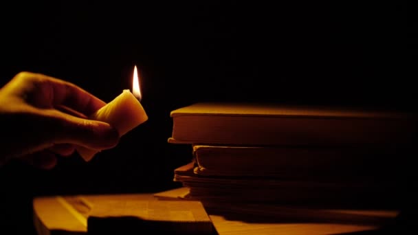 Knihy a svíčku. Oheň a kouř. Vytéká vosk. — Stock video