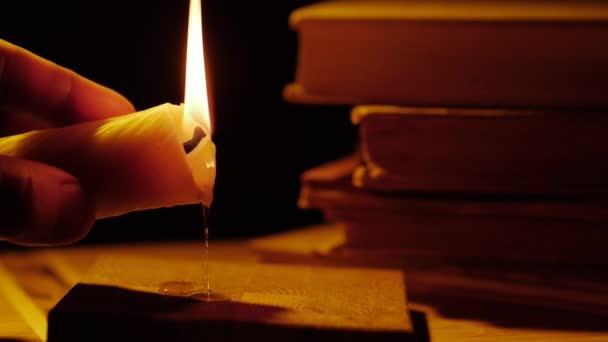 Boeken en kaars. Vuur en rook. Lekkende wax. — Stockvideo