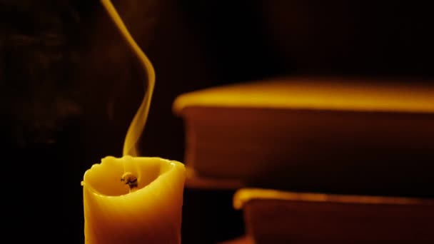 Books and candle. Fire and smoke. Light and blow out the candle. Slow motion. — Stock Video
