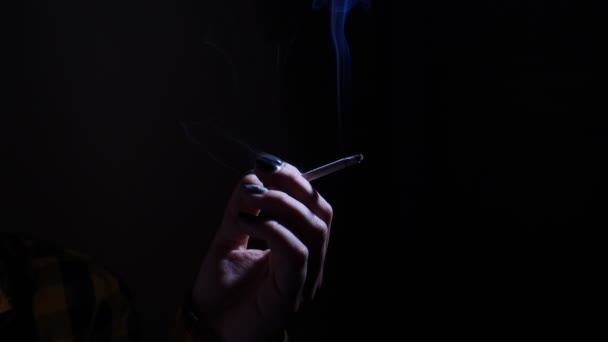 Een jonge vrouw die een sigaret te roken en te houden in haar hand. — Stockvideo