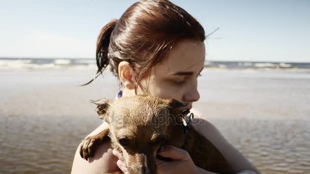 Meisje spelen met weinig hondje aan zee — Stockvideo