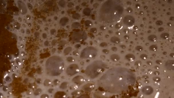 Rengeteg buborék egy koktél. Közeli kép a mixer korbácsolás tej smoothie a fahéjjal, a banán és a túrós. — Stock videók