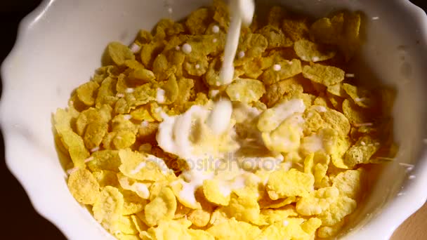 Milch gießt langsam in Schüssel mit Cornflakes — Stockvideo