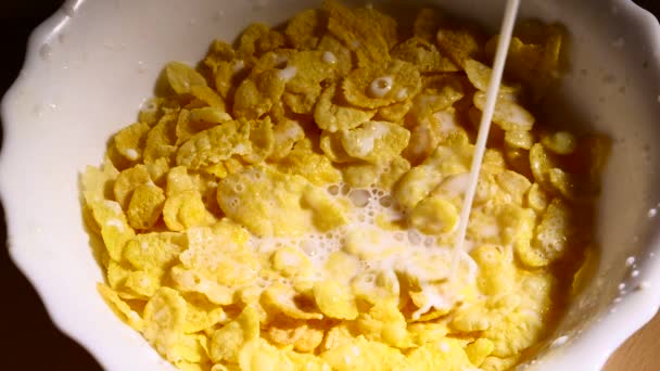 Milch gießt langsam in Schüssel mit Cornflakes — Stockvideo