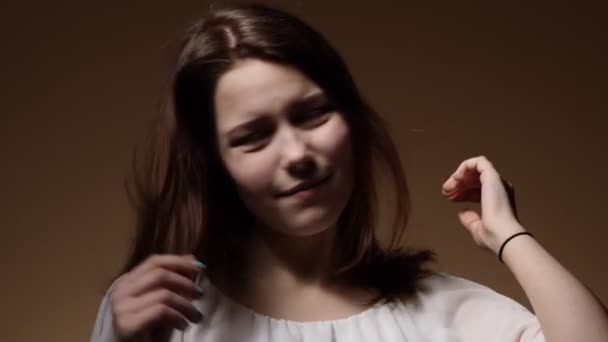 一个十几岁的女孩玩弄她的发型的肖像 — 图库视频影像