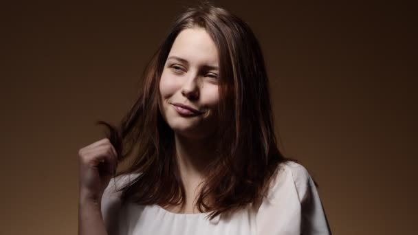 Портрет дівчини-підлітка, що грає зі своєю зачіскою — стокове відео