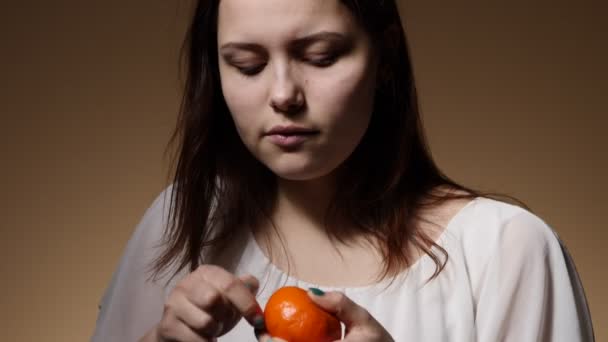 Cute teen girl eating tangerine — Stock Video