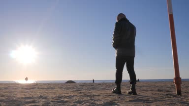 Deniz sahilinde yalnız adam silüeti