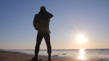 Deniz sahilinde yalnız adam silüeti