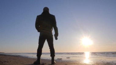 Deniz sahilinde yalnız adam silüeti