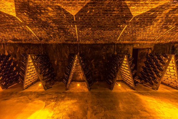 Sparkling wine bottles aging in old cellar, France