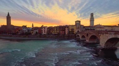 Sunset in Verona, Italy. View of old roman bridge Ponte di Pietra and Adige river flowing.