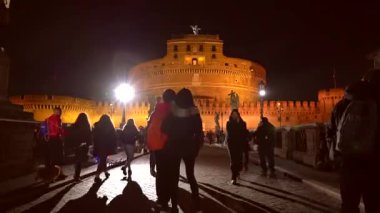 Roma, İtalya - 3 Aralık 2018: İnsanlar gece Roma, İtalya 'daki Castel Sant' Angelo köprüsünde yürüyorlar. 