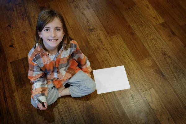 Youn Girl on Wood Floor with Paper and Pen — Stock Photo, Image