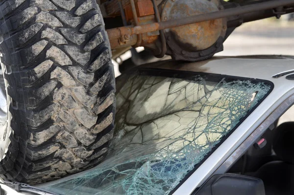 Wrak van de auto met vrachtwagen banden op de voorruit van kleine auto Crash Dest — Stockfoto