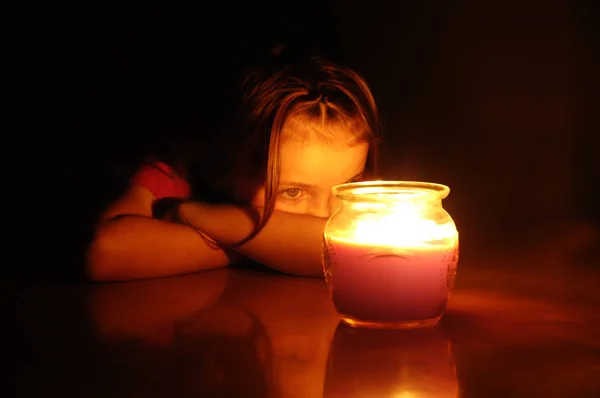 Malá holčička v noci zíral na osvětlené zářící svíčky — Stock fotografie