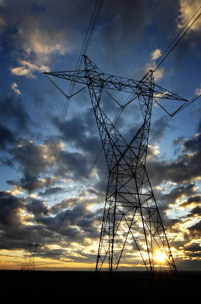 Elektromos vezetékek villamosenergia fém tornyok és naplemente — Stock Fotó