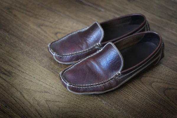 Comfortabele lederen Slippers op gepolijste houten vloer — Stockfoto