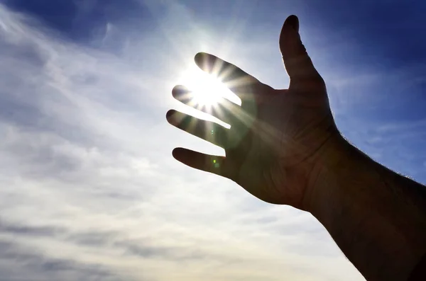 Main tendue vers la lumière du ciel Cherchant de l'aide — Photo