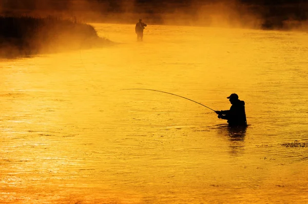 Silhouette dell'uomo Pesca a mosca nel fiume — Foto Stock