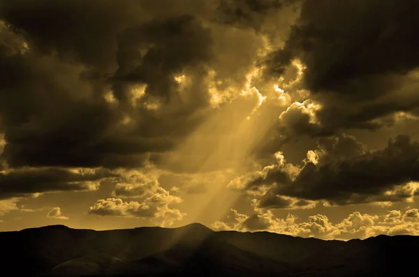 Güneş ışınları bulutlar ve dağlar — Stok fotoğraf