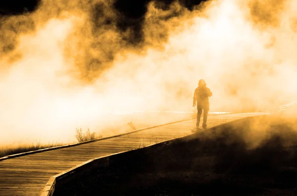 Donna che cammina attraverso vapore nebbioso sul lungomare — Foto Stock