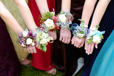Girls Holding Arms Out with Corsage Flowers for Prom clipart