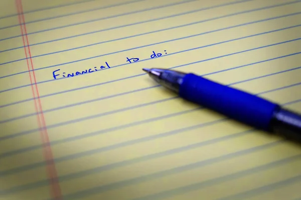 Να κάνουμε λίστα στο σημειωματάριο χαρτί και στυλό χρηματοοικονομικών — Φωτογραφία Αρχείου