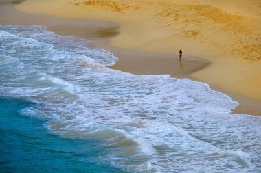 Güzel plaj dalgalar okyanus ve kız yürüyüş haddeleme