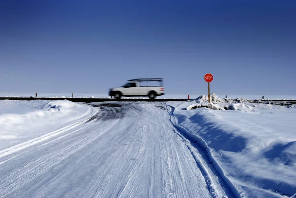 Stoppschild an Kreuzung bei winterschneeglatter Straße — Stockfoto