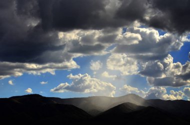 Güneş ışınları bulutlar ve dağlar