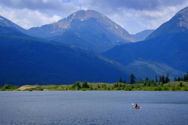 Man on Kayak on Lake Mountains Wilderness Paddling clipart