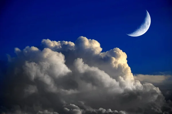 Luna creciente y nubes de trueno en el cielo azul claro — Foto de Stock