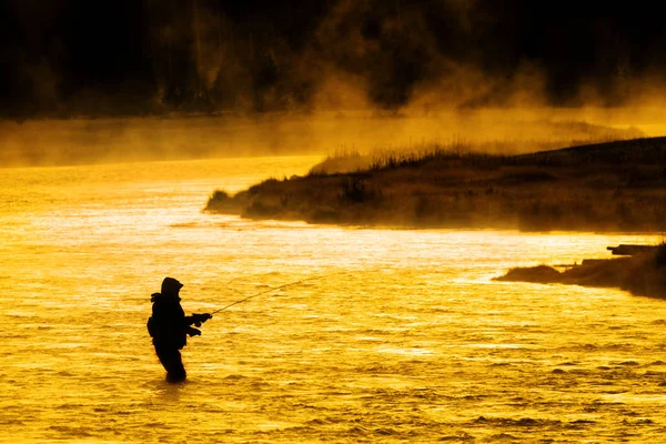 Σιλουέτα του ανθρώπου Flyfishing αλιεία στον ποταμό χρυσό φως του ήλιου — Φωτογραφία Αρχείου