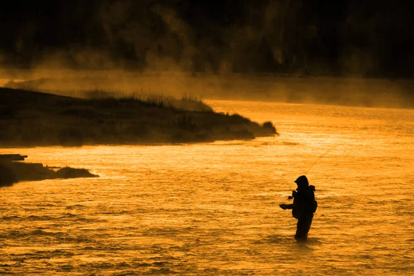 Σιλουέτα του ανθρώπου Flyfishing αλιεία στον ποταμό χρυσό φως του ήλιου — Φωτογραφία Αρχείου