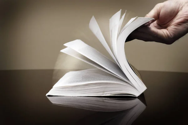 Το βιβλίο και το χέρι Flipping σελίδες ανάγνωση πληροφοριών — Φωτογραφία Αρχείου