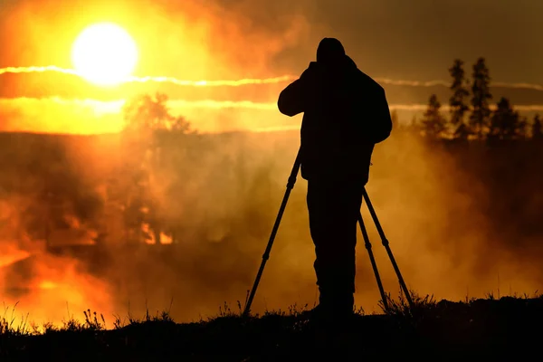 Fotograf mit Stativ, der Sonnenaufgang oder Sonnenuntergang fotografiert — Stockfoto