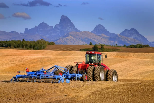 Tractor Farming Ground Harvesting Crops in Fall Autumn Teton Mou