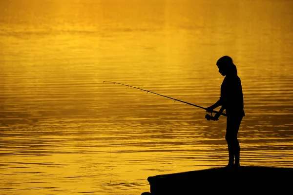 Jong kind kind persoon vissen in het meer of rivier zonsondergang — Stockfoto