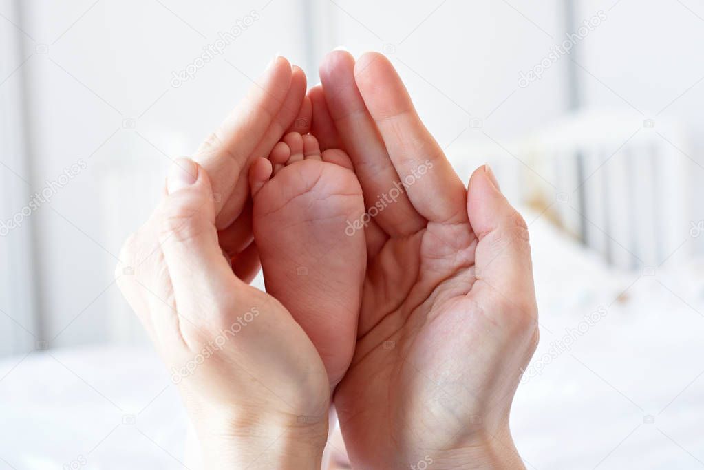 Parent holding in the hands foot of baby