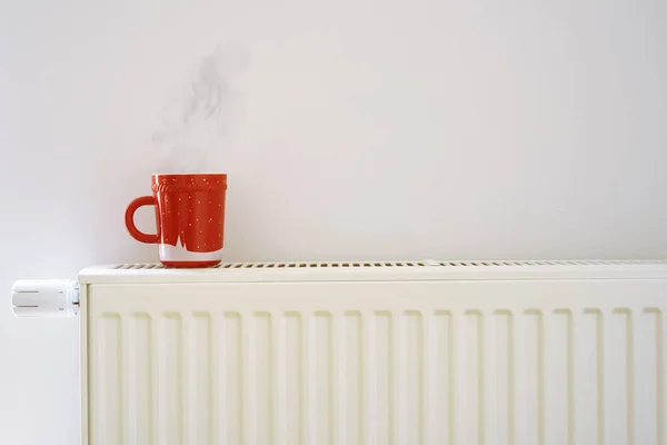 Taza roja en el radiador de calefacción — Foto de Stock