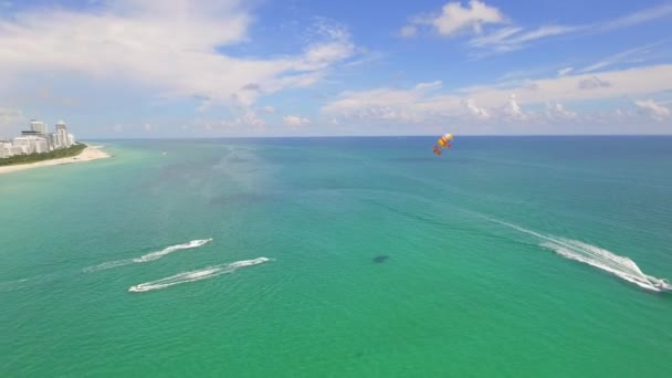 Wellenläufer und Parasailing am Strand von Miami — Stockvideo