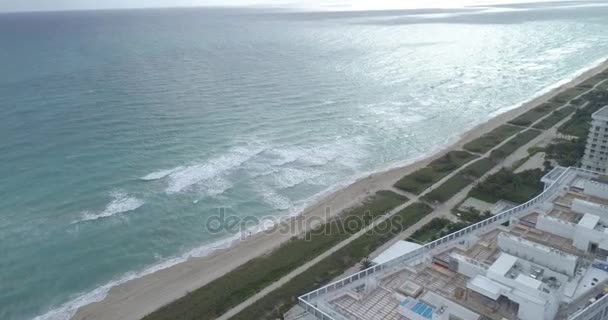 Снимки с воздуха, где волны разбиваются на пляже — стоковое видео