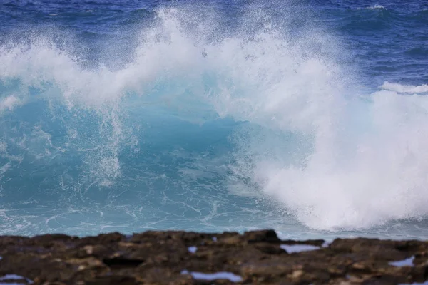 Wellen krachen mit verschwommenen Felsen im Vordergrund — Stockfoto