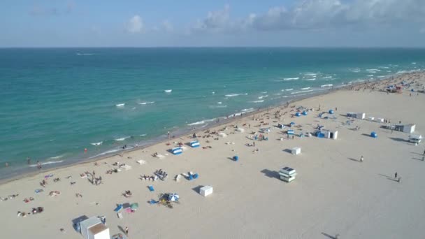 Inclinação aérea para baixo em turistas na praia 4k 60p — Vídeo de Stock