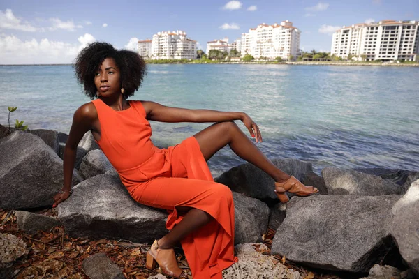 Aantrekkelijke jonge vrouw die zich voordeed in een lichte oranje jurk — Stockfoto