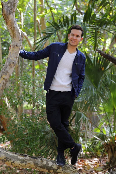 Homem sorridente na natureza posando entre árvores — Fotografia de Stock