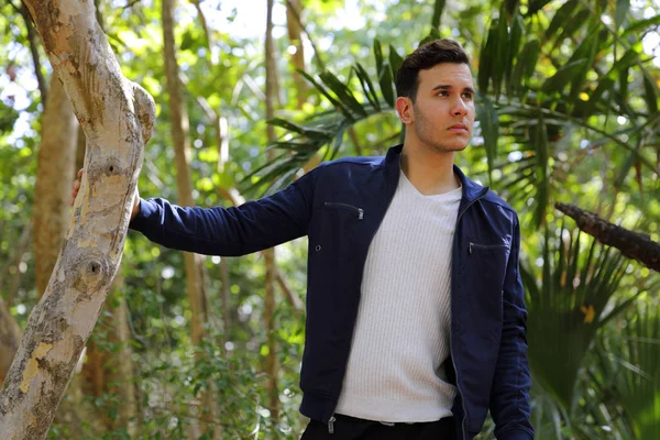 Man in a nature setting with hand on tree — Stock Photo, Image