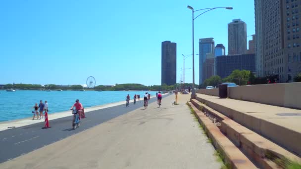 Vídeo de Lakefront Trail inclinar-se revelar Chicago arranha-céus edifícios — Vídeo de Stock